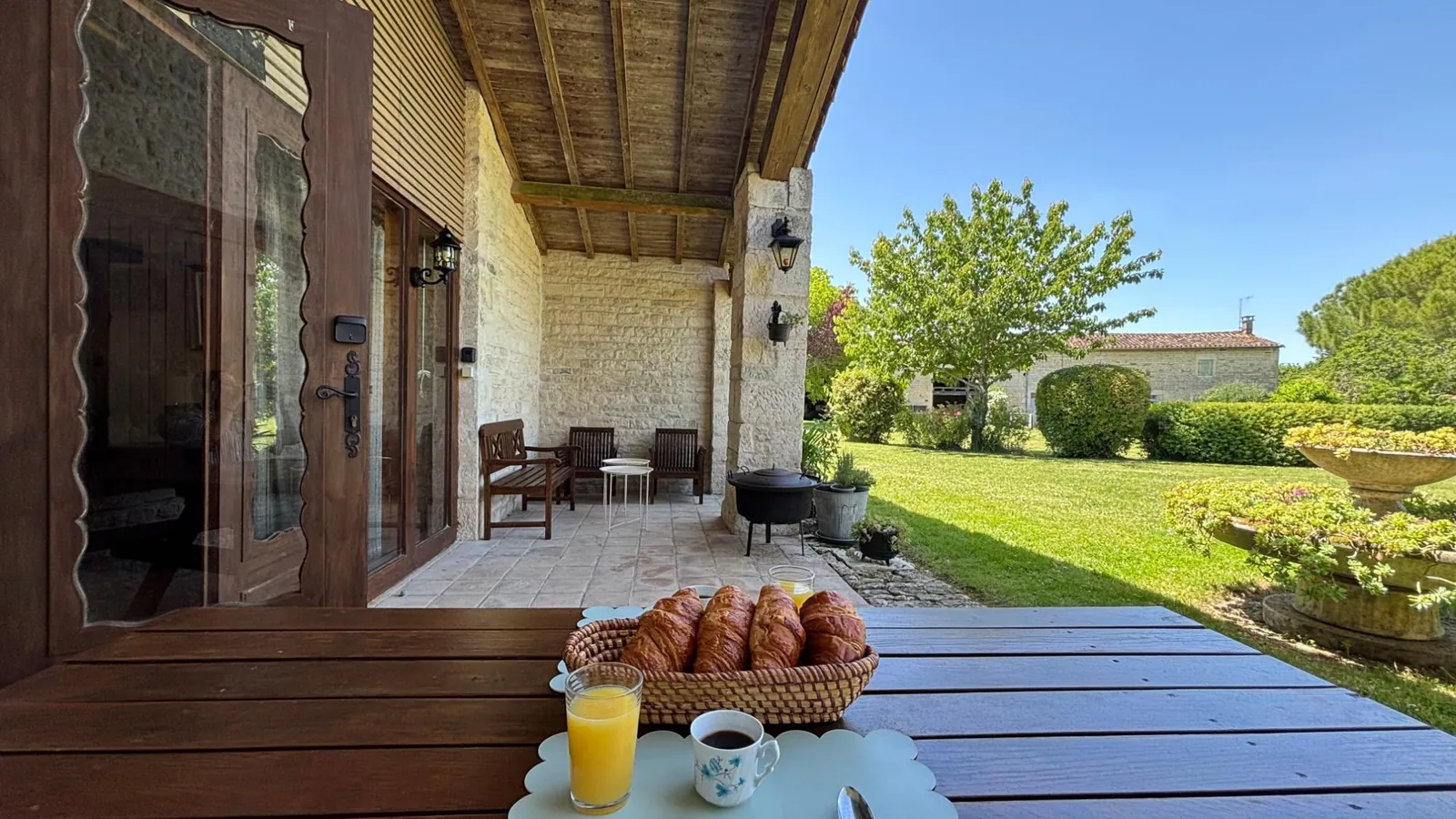 Petit-déjeuner servi sur la terrasse d’un logement en location : croissants, jus d’orange et café
